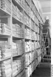 Magazinraum mit Aktenregalen im Reichsarchiv in Potsdam: Archivmitarbeiter beim Ausheben von Akten, März 1930